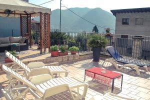 eine Terrasse mit Stühlen, einem Tisch und einem Pavillon in der Unterkunft B&B Tina in Monte Isola