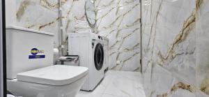 a bathroom with a toilet and a washing machine at Arevot Ojakh in Areni