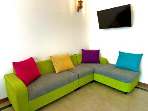 a green couch with colorful pillows in a room at Villa Bellezza in Pelena