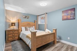 卡尔加里Private Family Entertainer's Suite的一间卧室配有一张床和一个带灯的梳妆台