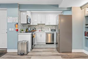 卡尔加里Private Family Entertainer's Suite的配有白色橱柜和不锈钢冰箱的厨房