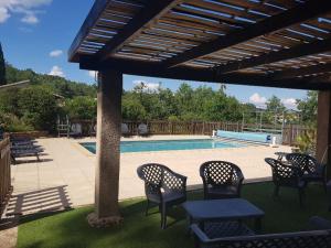 a patio with chairs and a swimming pool at GÎTES LES LAUZIÈRES CLIMATISÉS avec PISCINE in Tauriers