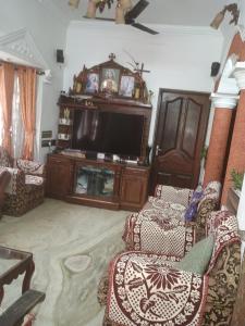 a living room with a flat screen tv and chairs at IDANN Homestay in Cochin
