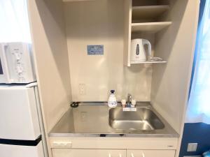 a small kitchen with a sink and a refrigerator at Nexoni Tenjin in Fukuoka +28 photos