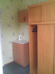 a bathroom with a sink and wooden cabinets at OW Gromada Pod Topolami in Międzyzdroje