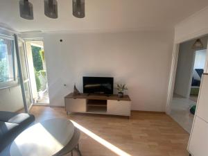 un soggiorno con TV su una parete bianca di STARY RYNEK Apartament Centrum a Słupsk