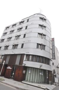 a tall white building with windows on a street at Hotel Boston Club (Adult Only) in Tokyo