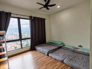 a bedroom with two beds and a large window at APPLE CloverLeafs Homestay Melaka in Melaka +23 photos