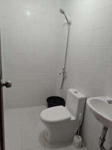 a white bathroom with a toilet and a sink at JV tRansient 24 in Ormoc