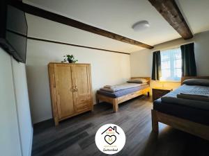 a room with two beds and a cabinet in it at Family M Apartments 16-17-18 in Sempach