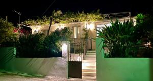 a house with lights on the front of it at Bee Home - Holiday Cottage in Agia Effimia