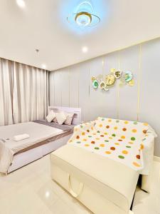 a bedroom with two beds and a chandelier at Beautiful Hotel Vinhomes Grand Park - Long Bình in Gò Công