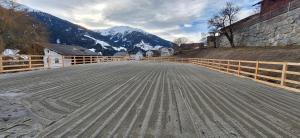 an empty road with a fence and mountains in the background at Reiterhof Romanasa Ferienwohnung in Fliess