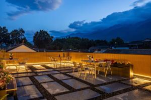 un patio con tavoli e sedie su una recinzione di Dali Yunqi Wangyue丨Guanshan Luxiao Ancient City Resort a Dali