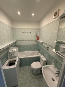 a bathroom with a tub and a toilet and a sink at Chic & Cozy Beige Studio in Bratislava