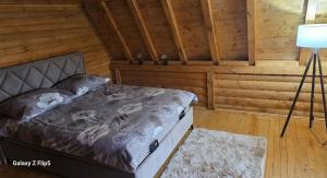 a bedroom with a bed in a wooden room at Vila&Spa Peric in Brčko