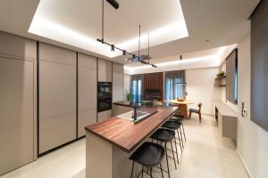 a kitchen with a long island with bar stools at Kyma Luxury Apartment in Rhodes Town