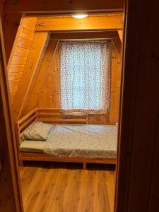 a small room with a bed and a window at AA Apartman - Tópart in Kaposvár