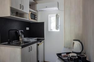 a small kitchen with a sink and a microwave at Albatross Breeze Bungalow 100m from the beach in Varna City