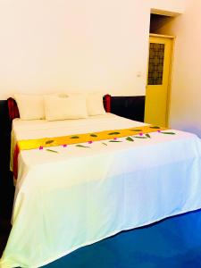 阿鲁甘湾Marina Way Beach Hotel Surf & Tour的卧室配有带鲜花的白色床 更多37张照片
