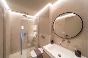 a bathroom with a shower and a sink and a mirror at Kyma Luxury Apartment in Rhodes Town +17 photos