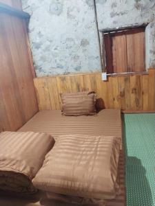 a bedroom with two beds and a stone wall at Triệu hoan homestay in Dam Thuy
