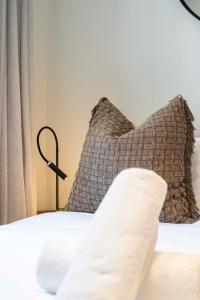 a bed with two pillows and a lamp on it at Lavish Living at The Braemar in Cape Town +21 photos