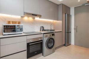 a kitchen with a washing machine and a microwave at Lavish Living at The Braemar in Cape Town
