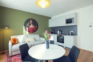 a living room with a table and a couch and a kitchen at LeonArt Living 44 in Graz