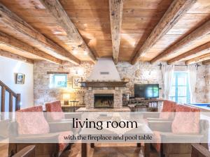 a living room with a fireplace and wooden ceilings at Villa Giselle - Oasis among olive trees in Vižinada