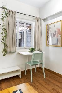 a desk and a chair in a room with a window at Tori 1BHK Bandra W by The Bombay Home Company in Mumbai