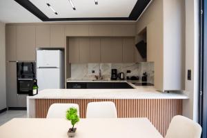 a kitchen with white appliances and white tables and chairs at Seven Luxury in Belek