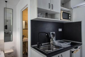 a kitchen with a sink and a microwave at Albatross Breeze Bungalow 100m from the beach in Varna City