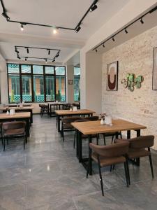 um restaurante com mesas e cadeiras de madeira e janelas em Hotel Love em Kobuleti mais 16 fotografias
