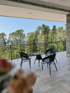 um pátio com cadeiras e mesas em uma varanda em Hotel Love em Kobuleti