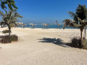 a sandy beach with palm trees and the ocean at Studio at Bab Al Bahr RAK in Ras al Khaimah +1 photo