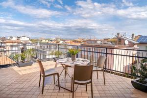 a patio with a table and chairs on a balcony at Hotel Capinera in Caorle