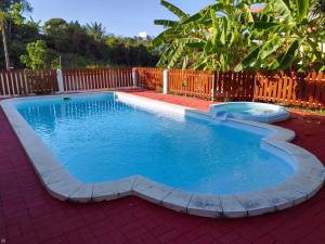 a small swimming pool in a backyard with a fence at Sandy Home in Grande Gaube