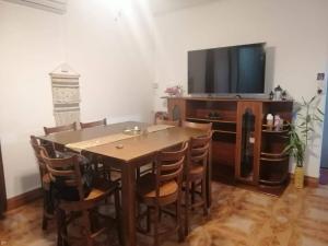 a dining room with a table and a flat screen tv at Sandy Home in Grande Gaube