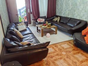 a living room with a leather couch and a table at Sandy Home in Grande Gaube