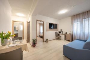 a living room with a blue couch and a table at Hotel Capinera in Caorle