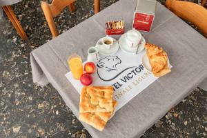 a table with a tray of breakfast food on it at Hotel Victoria in Finale Ligure