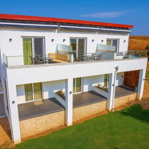 an external view of a white house with a deck at Chalkidiki's Seaview Escape - Cozy Summer Getaway in Nea Potidaea
