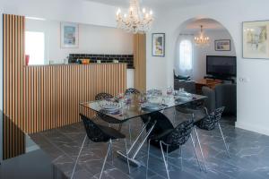 une salle à manger avec une table et des chaises en verre dans l'établissement WELCS CASA 111 EMP con piscina, à Empuriabrava