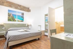 una camera da letto con un letto e una scrivania in una stanza di Hotel Victoria a Finale Ligure