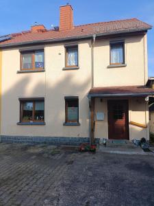 a white house with a red door at Silberranch Niederlichtenau in Lichtenau