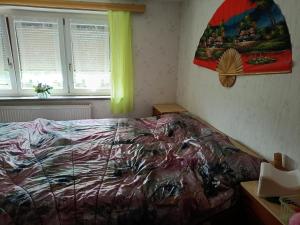 a bedroom with a bed and a painting on the wall at Silberranch Niederlichtenau in Lichtenau