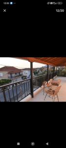 a balcony with tables and chairs and a boat at Denaxas apartments 0 in Elia Laconias