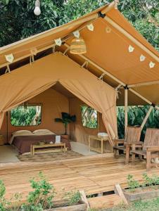 a tent with chairs and a bed in it at Binifarm Tropical Retreat in Cu Chi