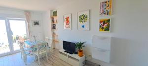 a living room with a television and a dining room table at Apartmani Mentha & Lipa in Novi Vinodolski
